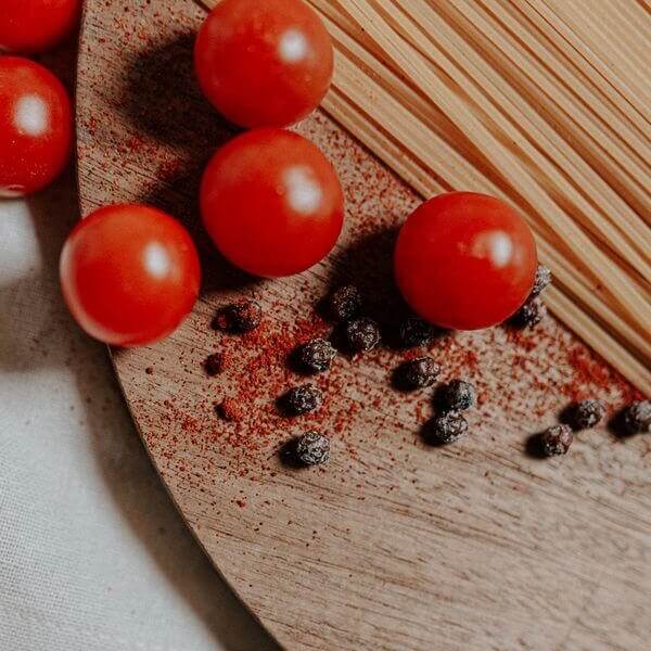 gros plan sur des grains de poivre rouge frais au sel avec des tomates